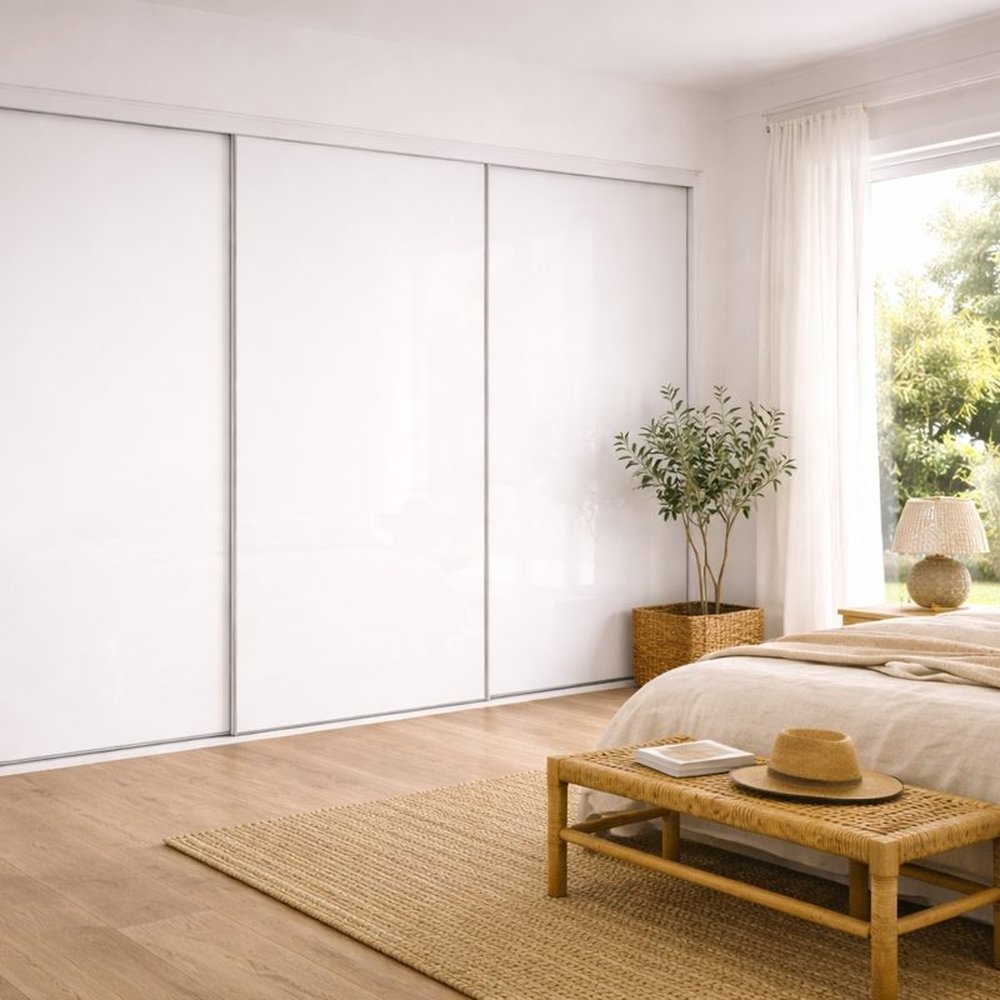White glass frameless sliding wardrobe doors in a bedroom